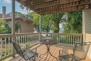 A covered outdoor area with a table and chairs, a view of a house, and a tree. - Riverfront Suites • Fireplace • Whirlpool for Two • Walk to Downtown (Wisconsin Dells)