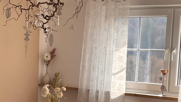 A dining area with a table, chairs, a vase with flowers, and a window with a view. - Fruntz Vacation Rental – A Family-Friendly Getaway in Franconian Switzerland 🏡🌳 (Gößweinstein)