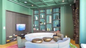 A modern living room with a curved white sofa, a flat-screen TV, and a decorative wall with shelves. - C1611 - Modern Boho Retreat with Pool & City Views in Miami Downtown (Miami)