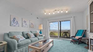 Un salon avec un canapé, une table basse et une vue sur l’extérieur.