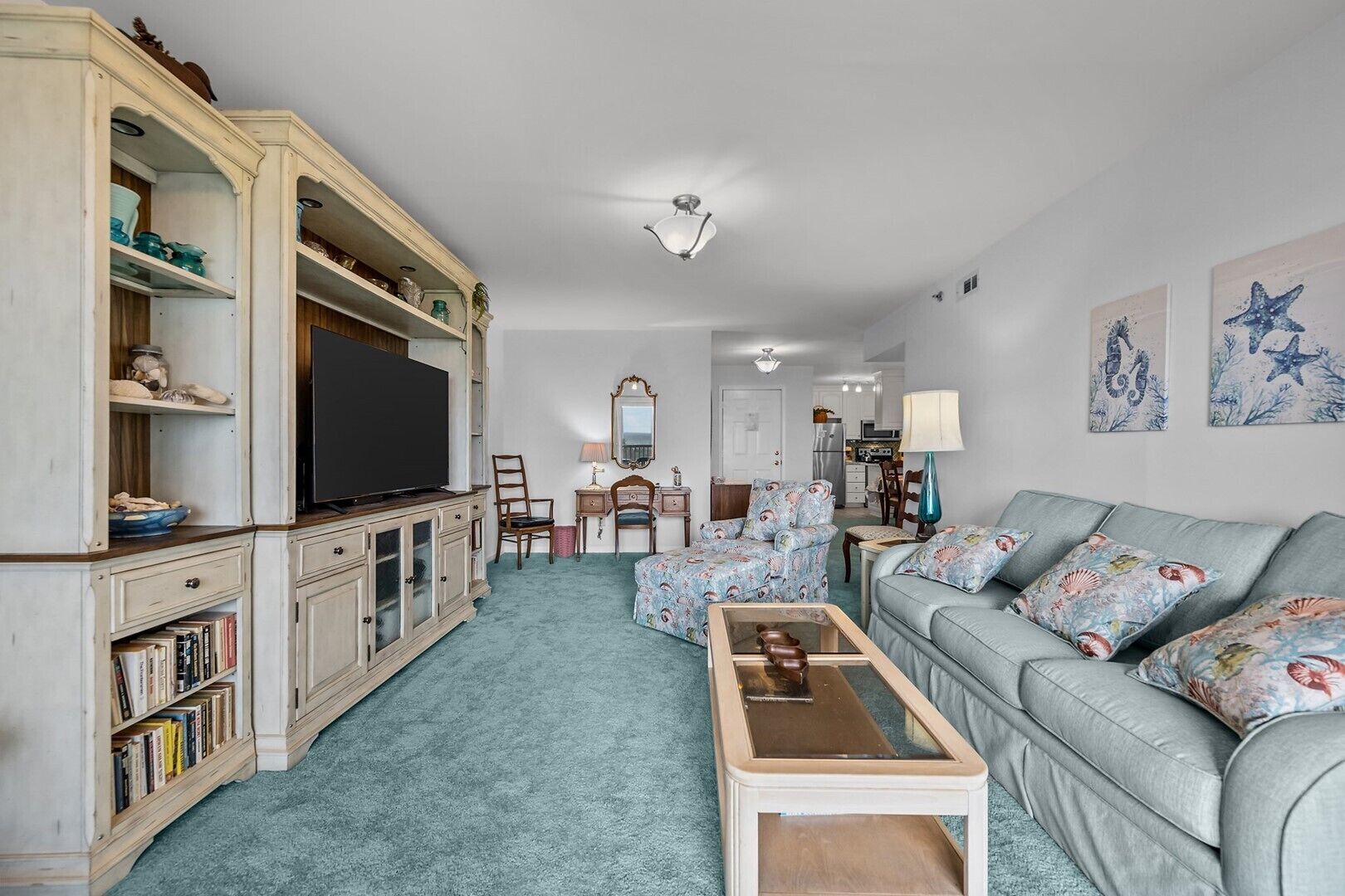 A living room with a television, sofa, coffee table, and a bookshelf.