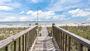 A wooden boardwalk leading to the beach with a clear sky and ocean in the background. - 'A Sunny Delight - 6BR - Oceanfront - Sleeps 15 (North Topsail Beach)