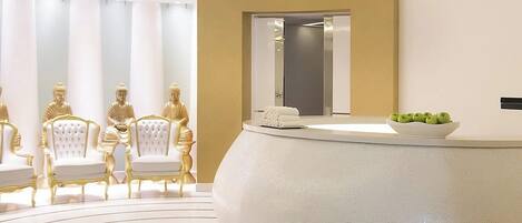 A modern reception area with a circular design, a large mirror, and golden statues.