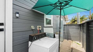 A laundry area with a washing machine, an IPod charging station, and a window. - Modern Pad w/ Game Room Arcade! (San Diego)
