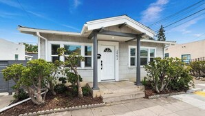 A modern two-story house with a white exterior, a front porch, and a small garden with trimmed bushes. - Modern Pad w/ Game Room Arcade! (San Diego)