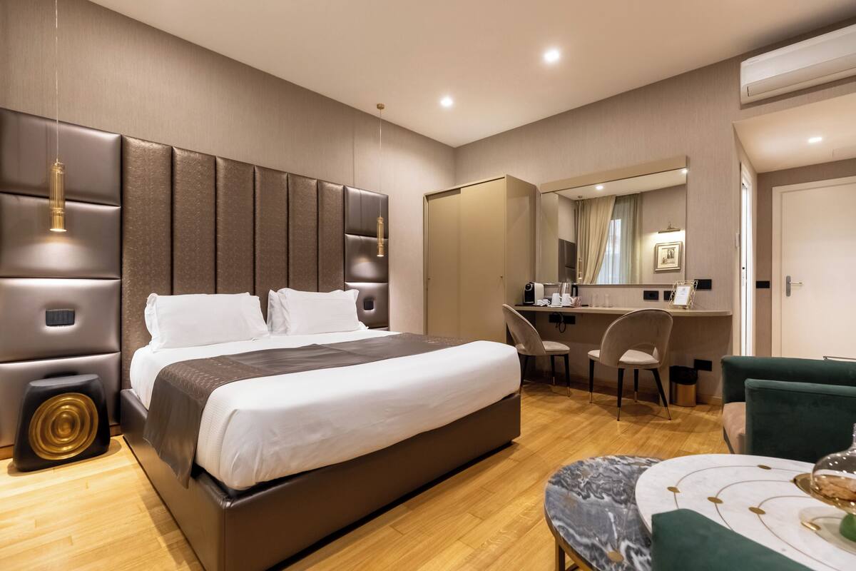 Une chambre d’hôtel moderne avec un grand lit, un bureau, une chaise et un miroir.