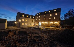 A large, multi-story building with a central courtyard, stone walls, and multiple windows. - Munkler Mühle Whg: 1 (Irrhausen)