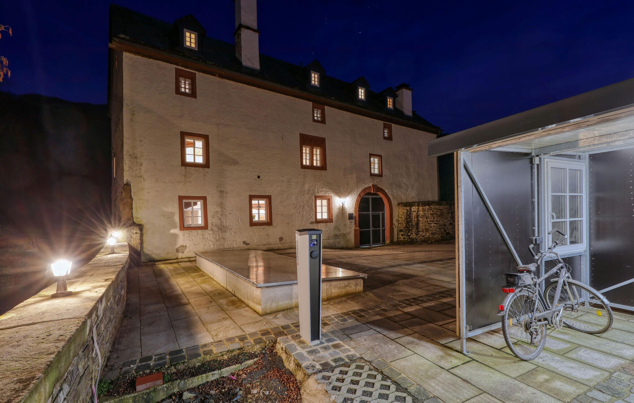Un edificio con varias ventanas, una entrada central y una bicicleta estacionada afuera.