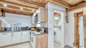 A modern kitchen with wooden beams, white cabinets, and a granite countertop. - 2 bedroom beautiful apartment in Irrhausen (Irrhausen)