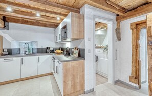 A modern kitchen with wooden beams, white cabinets, and a granite countertop. - 2 bedroom beautiful apartment in Irrhausen (Irrhausen)