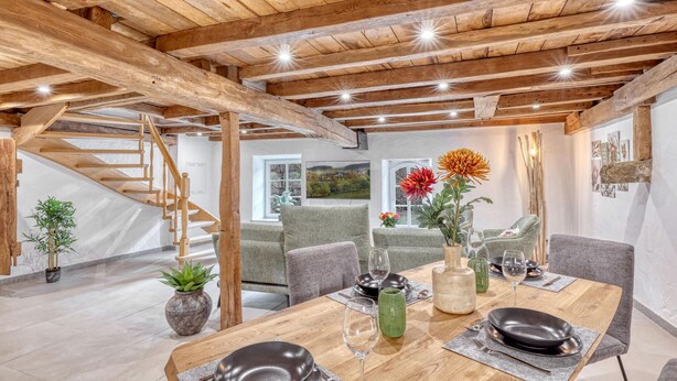 A dining area with a wooden table, chairs, and a staircase. - 2 bedroom beautiful apartment in Irrhausen (Irrhausen)