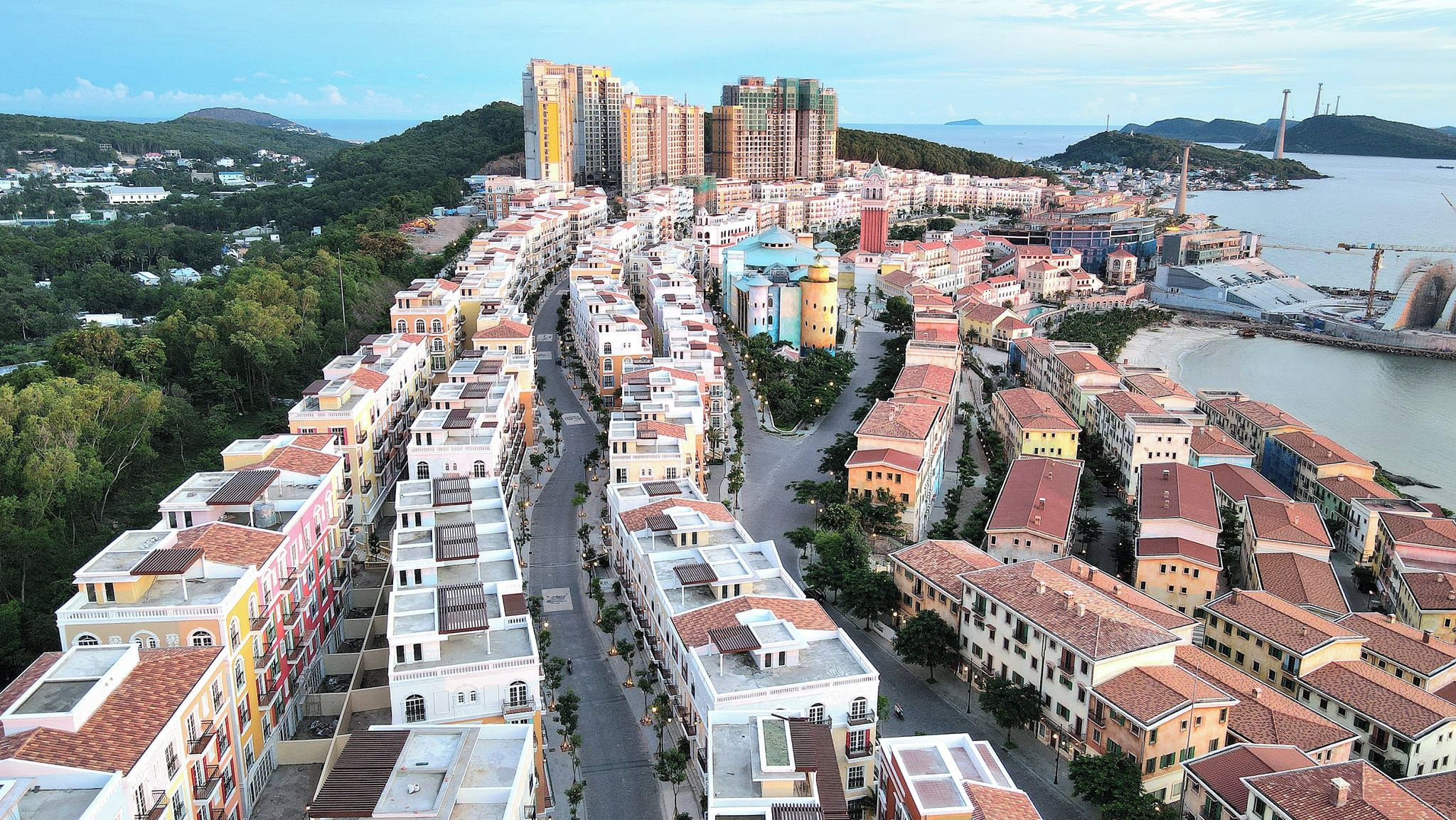 A coastal cityscape with a mix of residential buildings and a prominent tower.