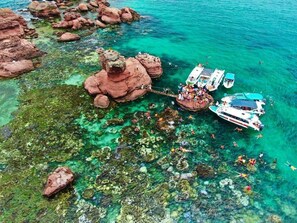 A coastal area with clear turquoise water, rocky formations, and boats. - MeyBeach Apartment & Hotel Phu Quoc (Phu Quoc)