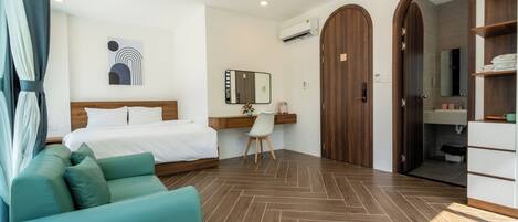 A hotel room with a bed, a desk, a chair, a wardrobe, and a bathroom.
