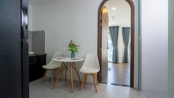 Ein stilvoller Essbereich mit Tisch und Stühlen, einer kleinen Pflanze und Blick in einen Wohnraum.