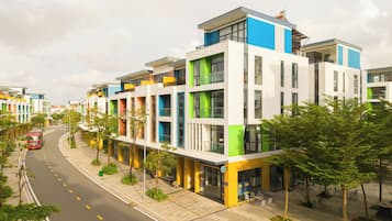 A modern multi-story building with a variety of window sizes and a flat roof.