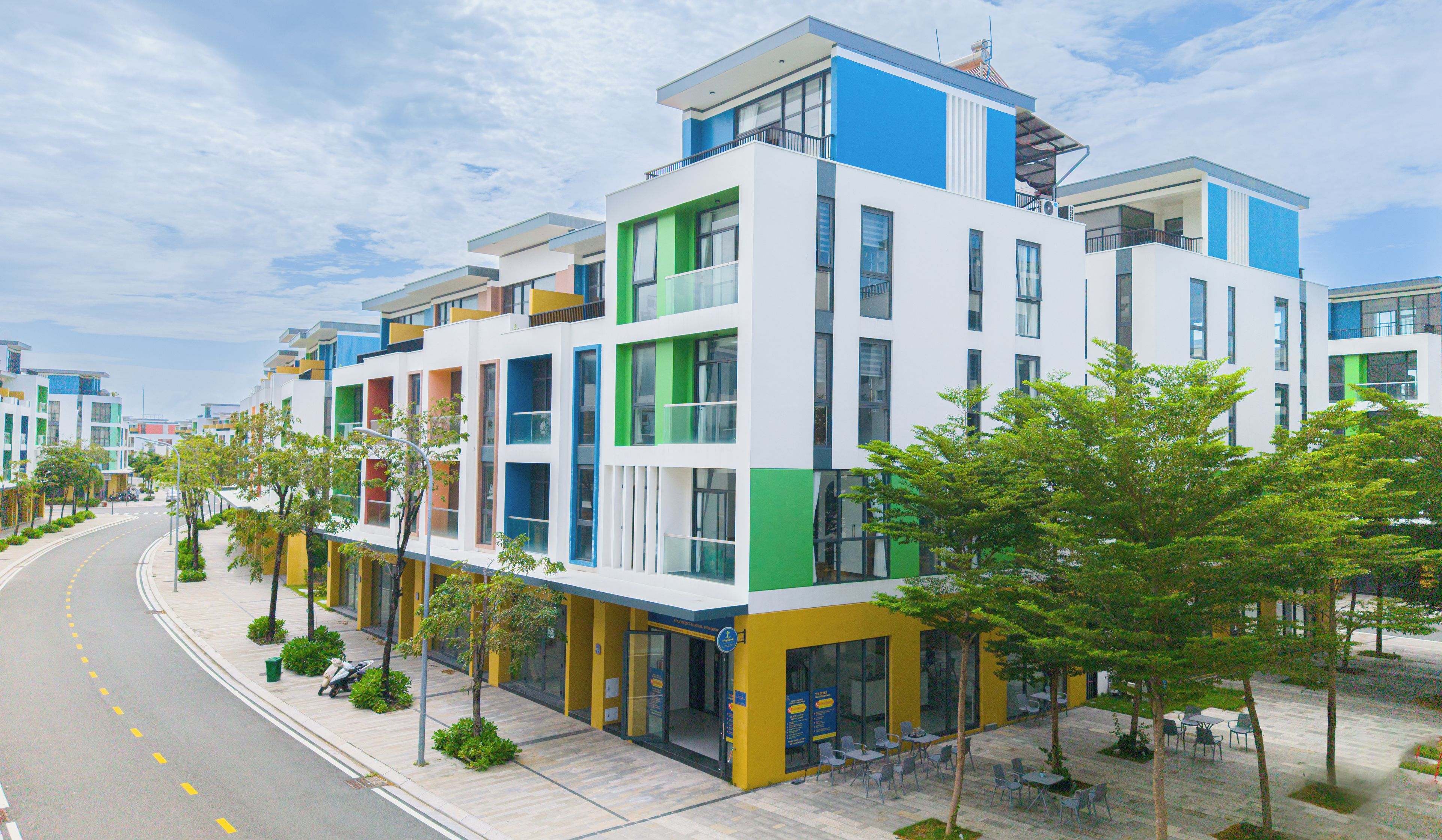 Un edificio moderno de varios pisos con techo plano, ventanas amplias y espacio comercial en la planta baja.