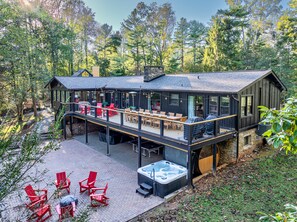 Eine Hütte mit Terrasse, Sitzgelegenheiten im Freien und einem Whirlpool.