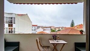 A balcony with a wooden chair, a small table, and two glasses of wine. - Parede Coastal Family Retreat (Cascais)
