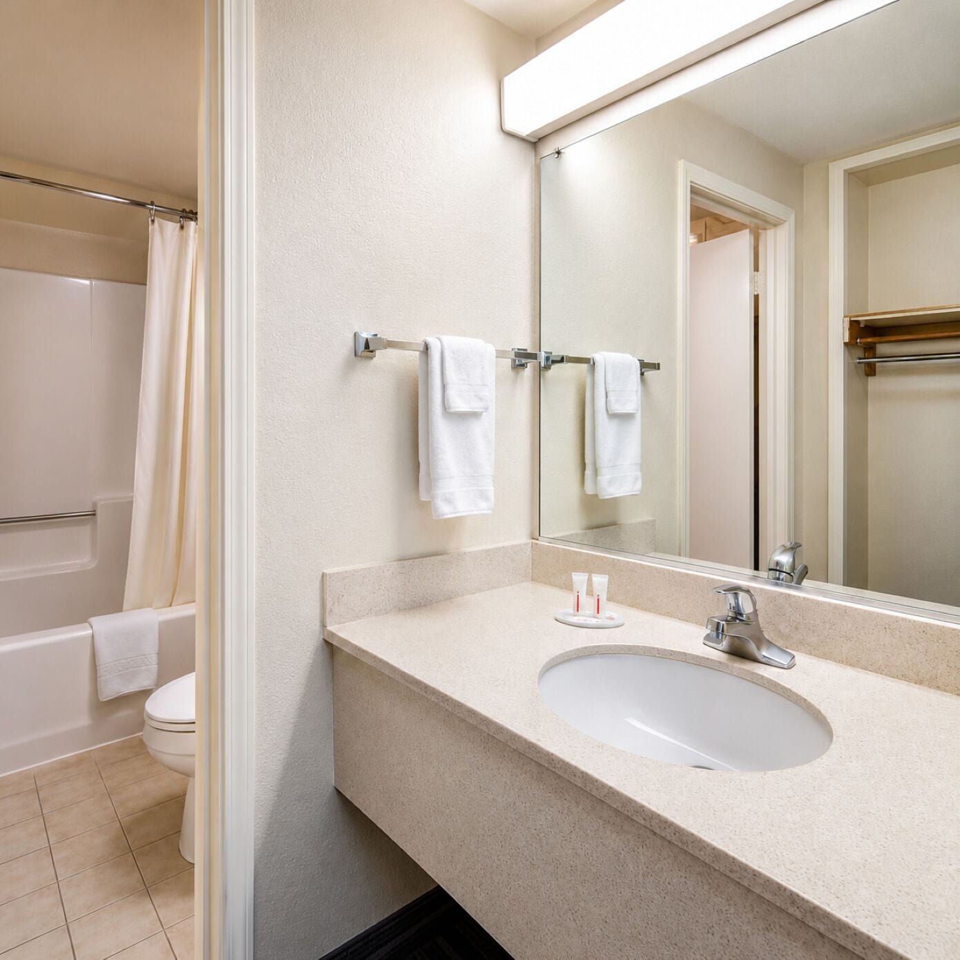 A bathroom with a bathtub, toilet, sink, and a mirror.