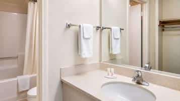 A bathroom with a bathtub, toilet, sink, and a mirror.