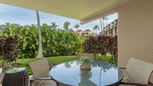 A round glass table with chairs, a small plant, and a decorative item on the table. - Kamaole Sands Condo | Ground Floor, 2 Bath, Pool, Hot Tub, AC, Walk to Beach (Kihei)