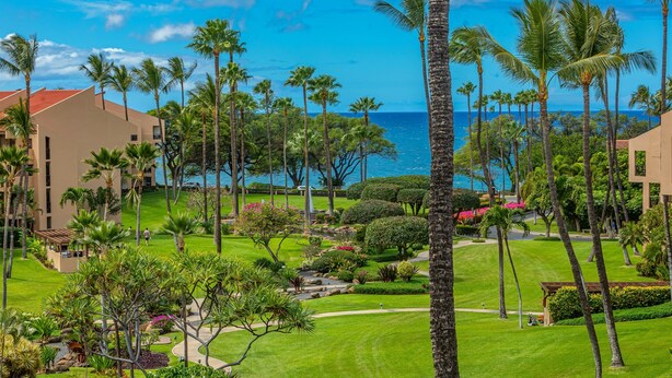 A resort with a golf course, palm trees, and a view of the ocean. - Kamaole Sands Condo | Ground Floor, 2 Bath, Pool, Hot Tub, AC, Walk to Beach (Kihei)