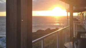 A wooden balcony overlooking a sunset over the ocean. - CRASHING WAVES AND WHALES! (Depoe Bay)