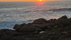 A sunset over the ocean with rocky terrain in the foreground. - CRASHING WAVES AND WHALES! (Depoe Bay)