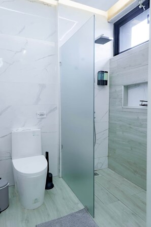 Un bagno con toilette, bidet e cabina doccia in vetro.