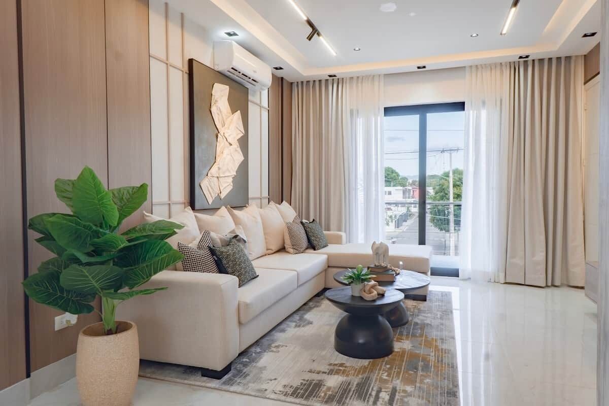 Un salon moderne avec un canapé, une table basse et une grande fenêtre.