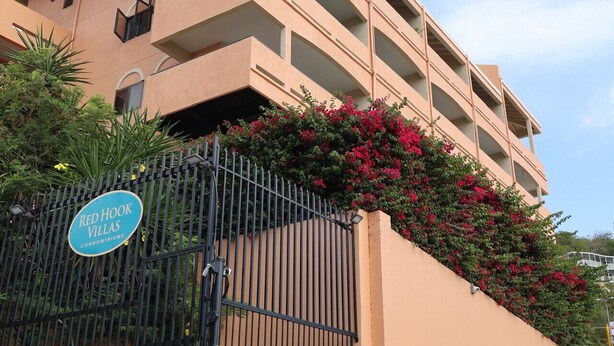 A multi-story building with balconies, a gated entrance, and a sign indicating 'Red Hook Villas'. - Red Hook Retreat with Stunning Ocean Views (Red Hook)
