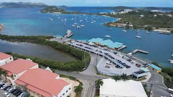 A marina with boats, a parking lot, and buildings with red roofs.