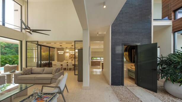 Ein modernes Interieur mit einem Glastisch, einer Couch und einem Essbereich.