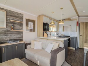 A modern kitchen with a central island, a built-in oven, and a microwave.