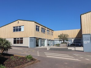 Un edificio con un letrero que dice 'FISH & CHIPS' y 'LADRAM BAY STORE', con un cielo despejado arriba.