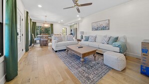 Un salon spacieux avec un grand canapé, une table basse et un tapis à motifs.