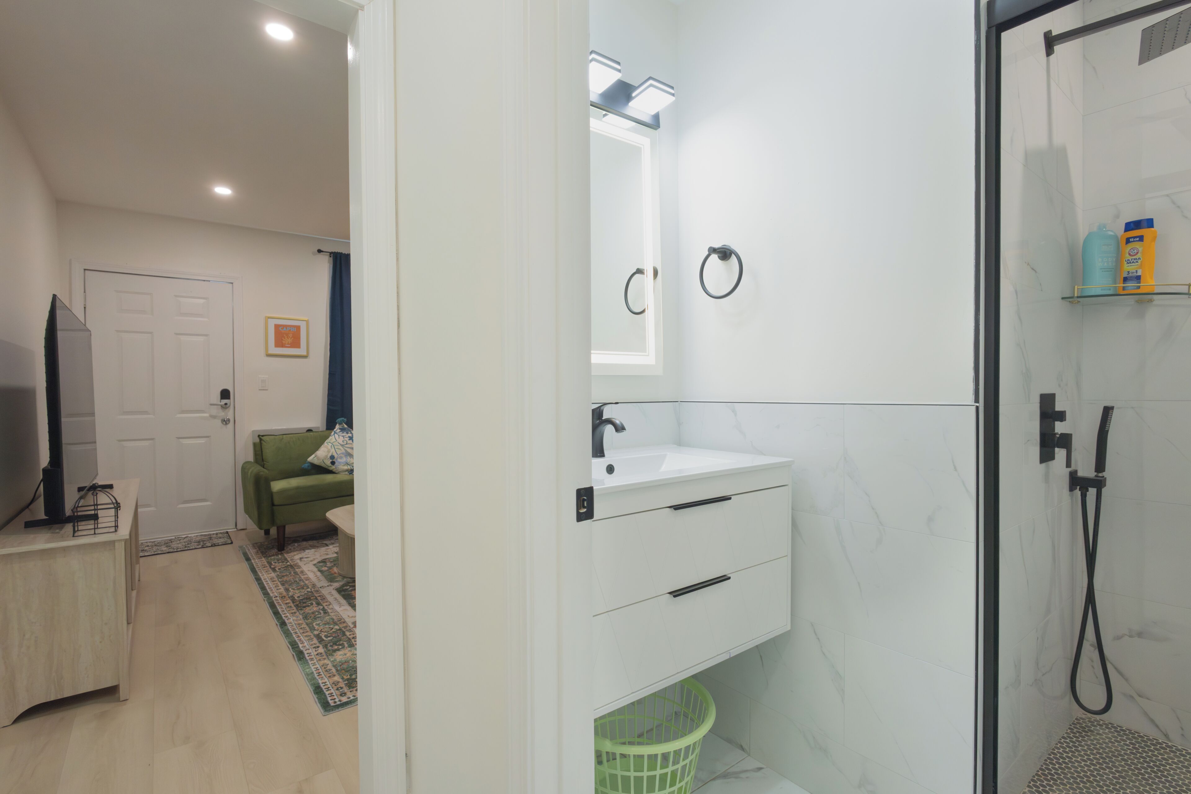 Een badkamer met een witte wasbak, spiegel en douche.