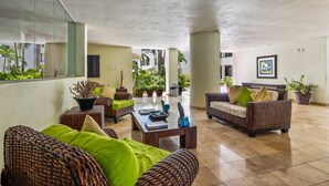 Un espace intérieur spacieux, aménagé avec des meubles en osier, une table basse et des plantes en pot.