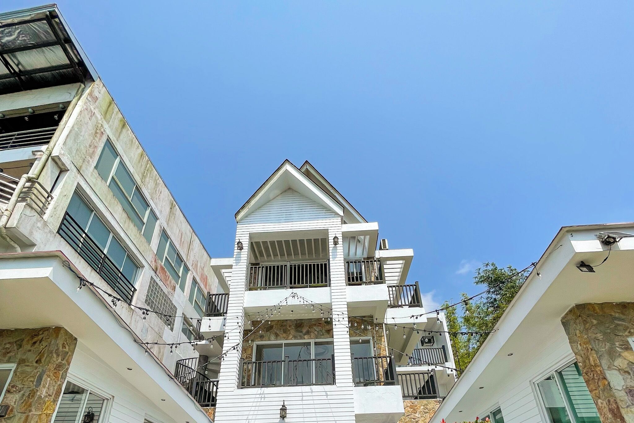 Un edificio de varios pisos con balcones, ventanas amplias y fachada de piedra.