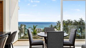 Uma varanda com vista para o mar e palmeiras.