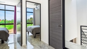 A modern bedroom with a large window, a ceiling fan, and a view of greenery outside. - 3BR/2.5BA Porto Residencial in Nuevo Nayarit, near ocean, pool, patio, WiFi (Nuevo Vallarta)