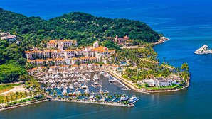A marina with boats, a hotel with red roofs, and a forested hill. - Coastal Couples Retreat | Plunge Pool + Hammocks (La Culebra)