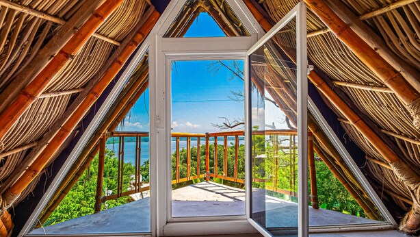A room with a large glass door leading to an outdoor balcony with a view of greenery and a clear sky. - Coastal Couples Retreat | Plunge Pool + Hammocks (La Culebra)