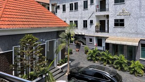 A multi-story building with a grey facade, red-tiled roof, and a sign reading 'Supreme Apartments.' - Supreme Apartments (Ibadan)