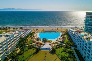 A resort with a swimming pool, beach access, and multiple hotel buildings. - Aria Ocean Condo, 1BR/1BA, Nuevo Vallarta—oceanfront pool, WiFi (Nuevo Vallarta)