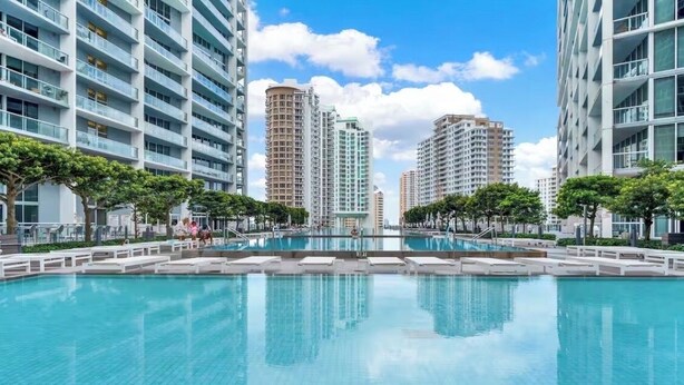 A swimming pool surrounded by modern high-rise buildings with balconies. - erfront 2BR Icon Brickell, 5-Star W Hotel Serenity Views - Wow! (Miami)