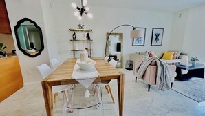 A dining area with a wooden table, chairs, a chandelier, a sofa, a coffee table, and a mirror. - erfront 2BR Icon Brickell, 5-Star W Hotel Serenity Views - Wow! (Miami)