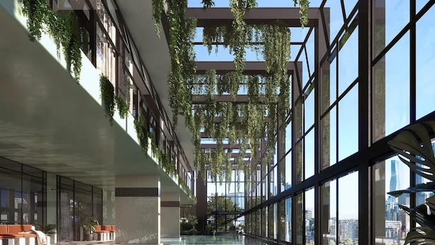 Une piscine intérieure dotée d’un plancher en verre, entourée de grandes fenêtres et agrémentée de plantes d’intérieur.