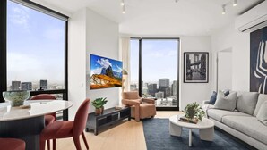 Un salon moderne avec vue sur la ville, un coin repas et un canapé.